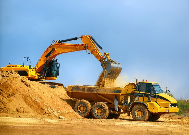 An excavator loading a truck.