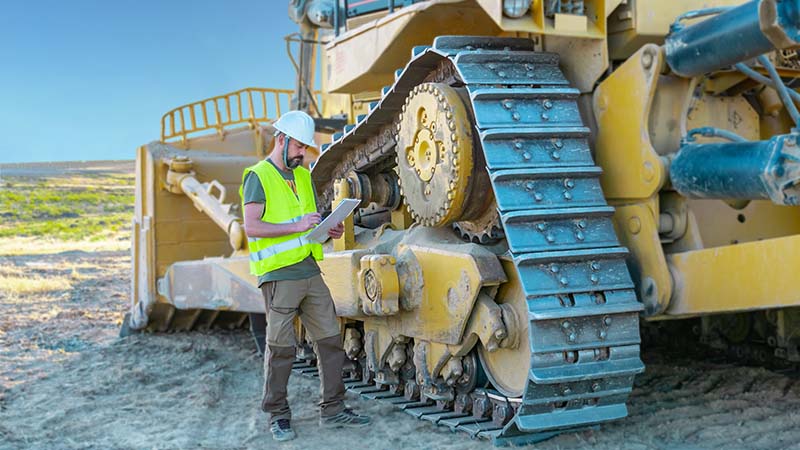 An operator inspects a dozer