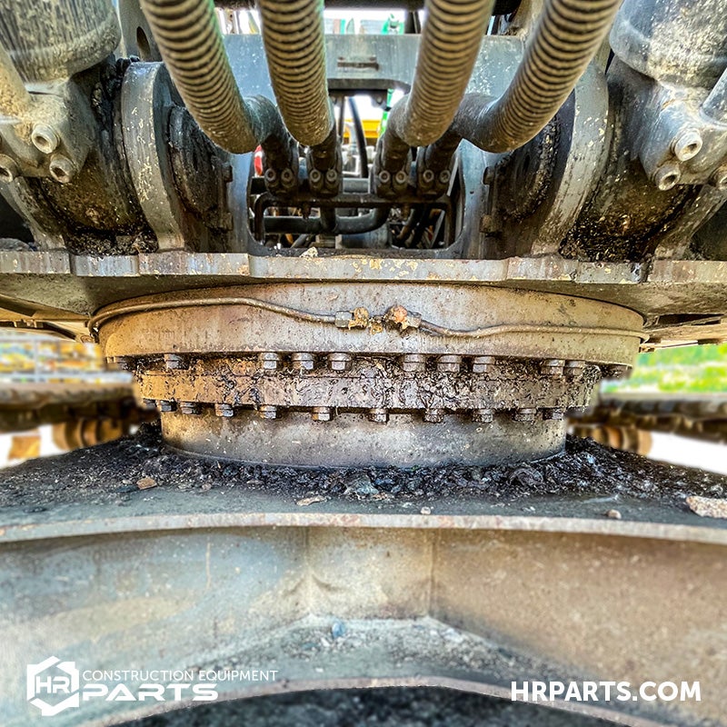 A slewing ring with grease escaping and collecting on the carbody.