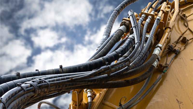 Clean hydraulic hoses on an excavator.