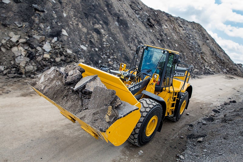 A wheel loader is loaded with rock.